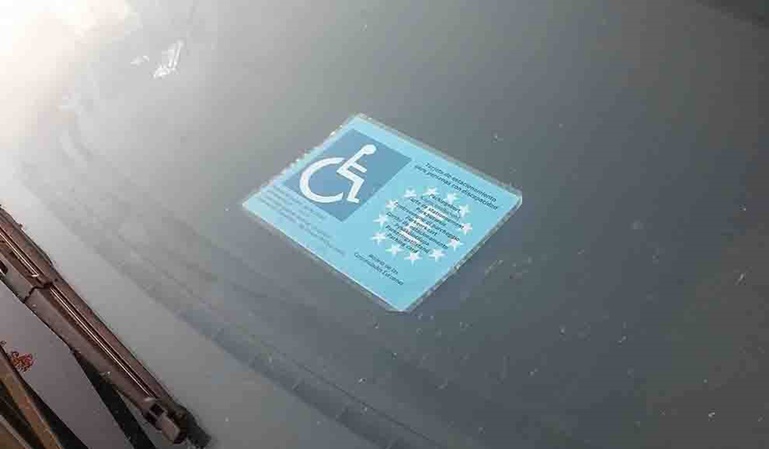 Imagen tarjeta de aparcamiento para personas con discapacidad en coche